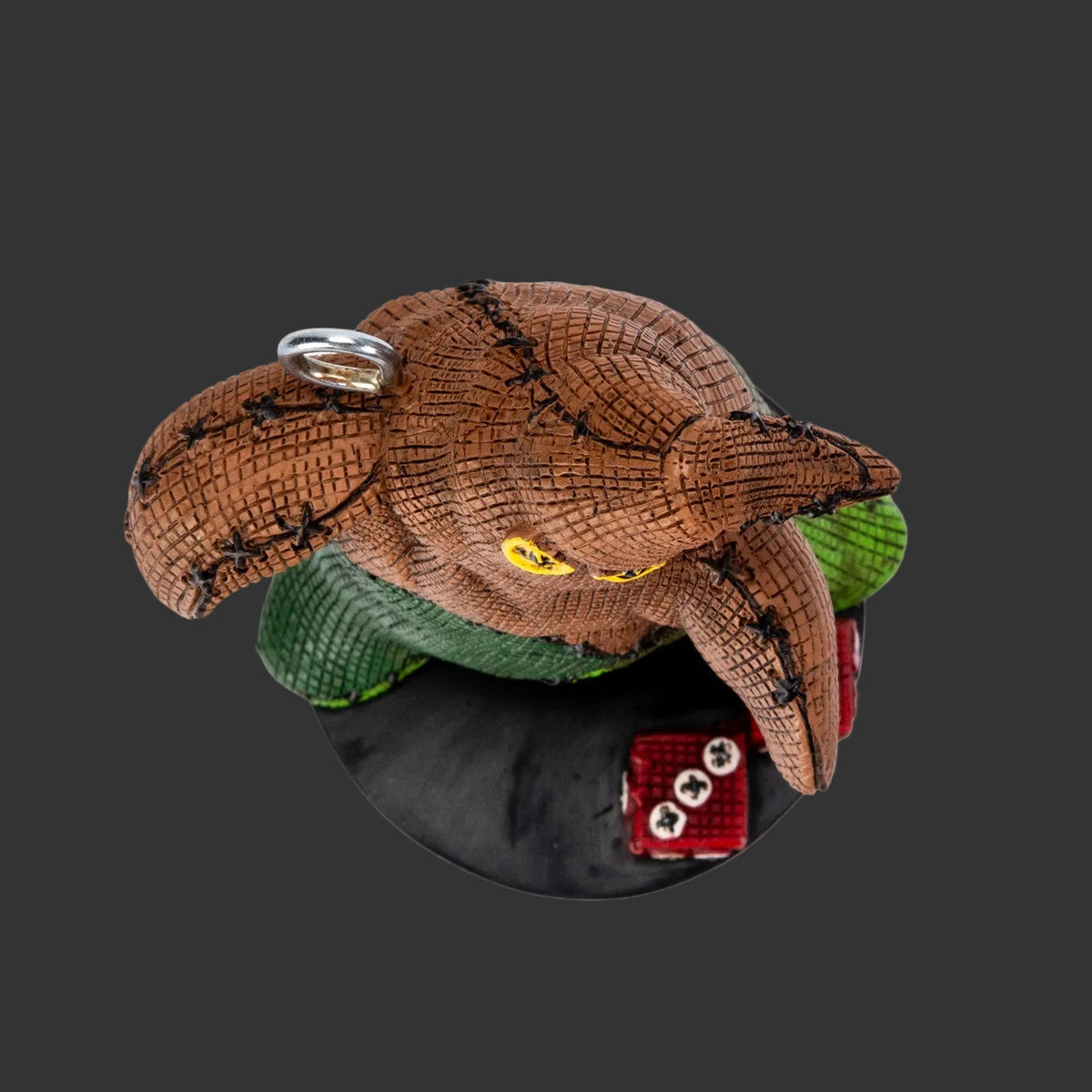 Top view of Oogie Boogie Pinhead Monster figurine showing hand-painted resin texture, metal ornament loop, and red dice detail, 2026 Pinhead Monsters collectible, white background