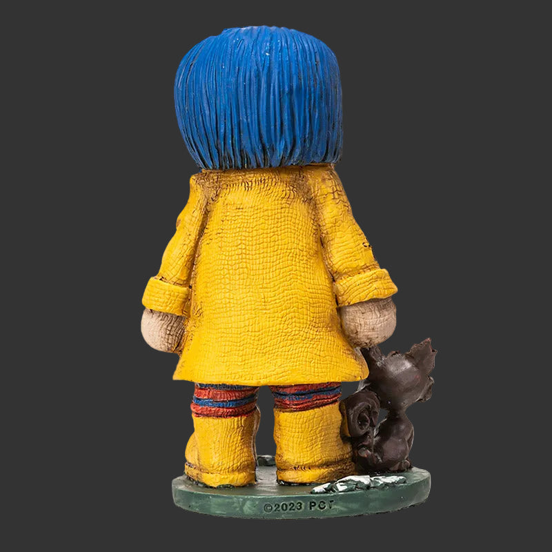 Pinhead Monster figurine of Coraline showing the reverse side with yellow raincoat detail and round base on a black background