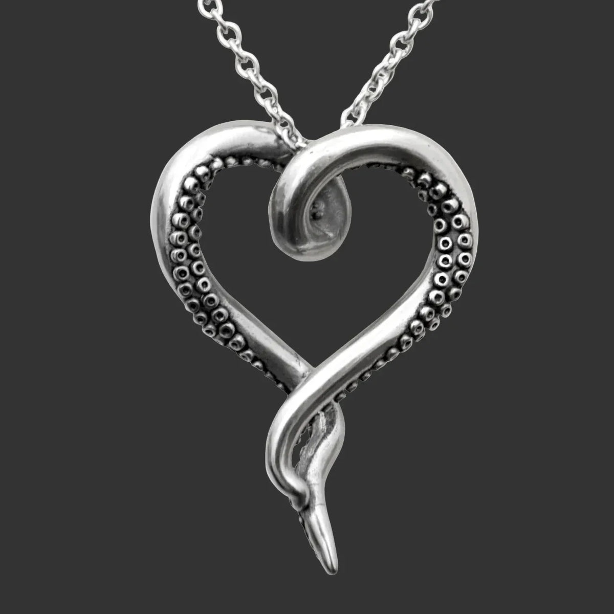 Controse octopus heart medallion stainless steel necklace with tentacle detail on a black background