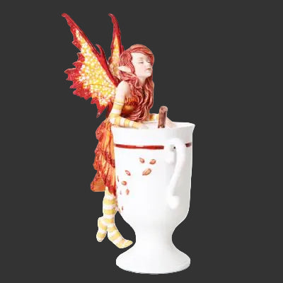 Amy Brown Fairy figure with red hair and wings sitting inside a white mug on a black background