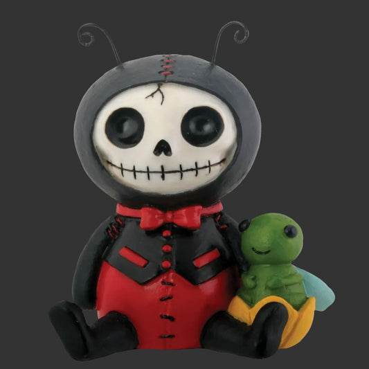 A stylized seated furrybones figuring resembling a stitched ladybug character with a black hood, white skull face, red outfit, and a small green winged creature on its lap, shown on a plain black background.