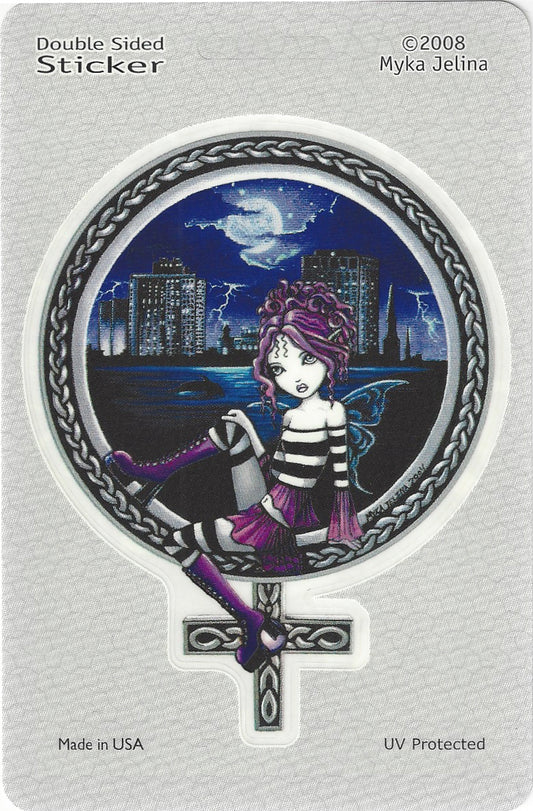 A double-sided sticker on a light gray backing card. The sticker features a gothic fairy girl with purple hair and a striped black-and-white dress, sitting on a Celtic-style cross against a dark blue city skyline at night with a full moon and lightning.