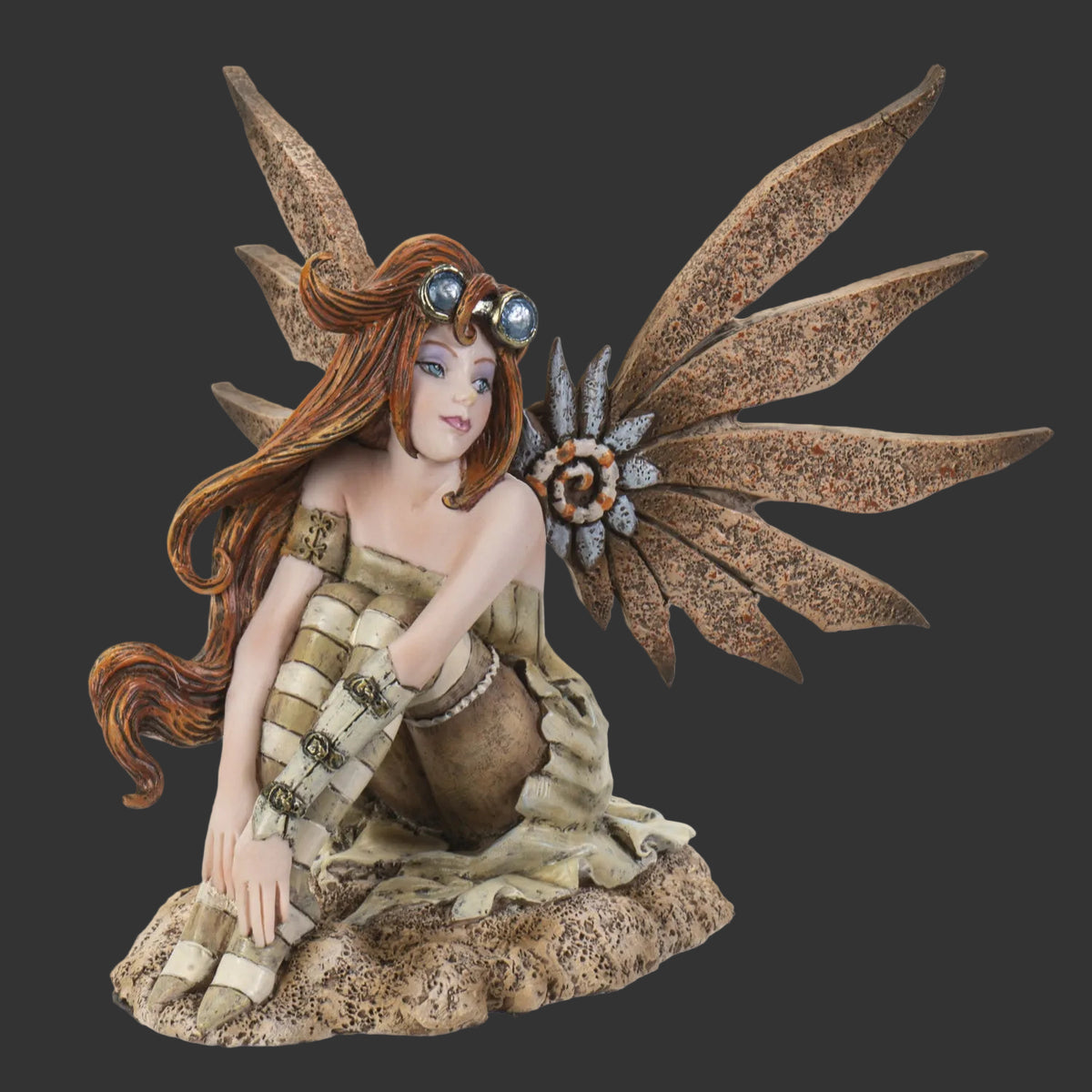 A fantasy Amy Brown fairy figurine with large brown wings, long reddish-brown hair, and goggles, posed kneeling on a textured base against a plain white background.