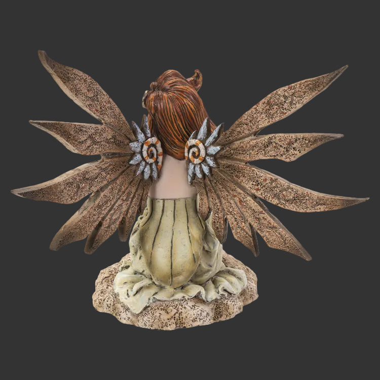 An Amy Brown fairy figurine shown from the back, featuring brown textured wings, brown hair, and a beige-green skirt, set against a plain white background.
