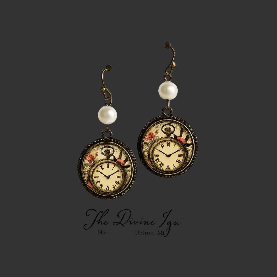 A pair of steampunk-style drop earrings displayed on a white card. Each earring has an antique bronze hook, a white pearl bead, and a round pocket-watch pendant with a floral design and Roman numerals.