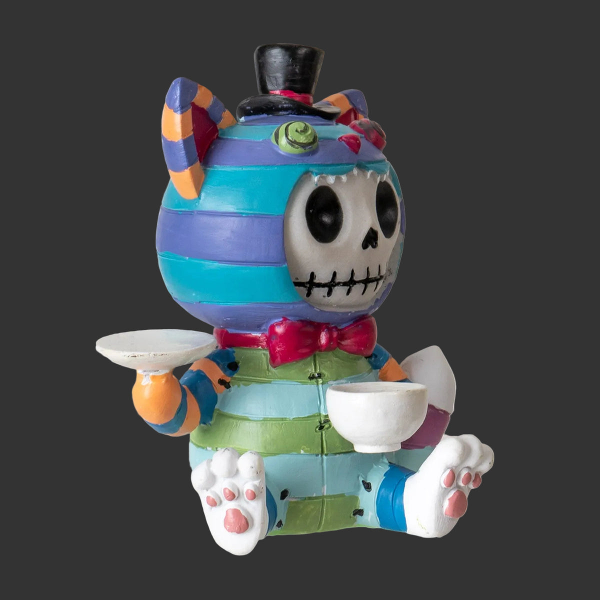 Colorful skeleton Chesire Cat Alice in Wonderland figurine with a top hat and bow tie on a black  background