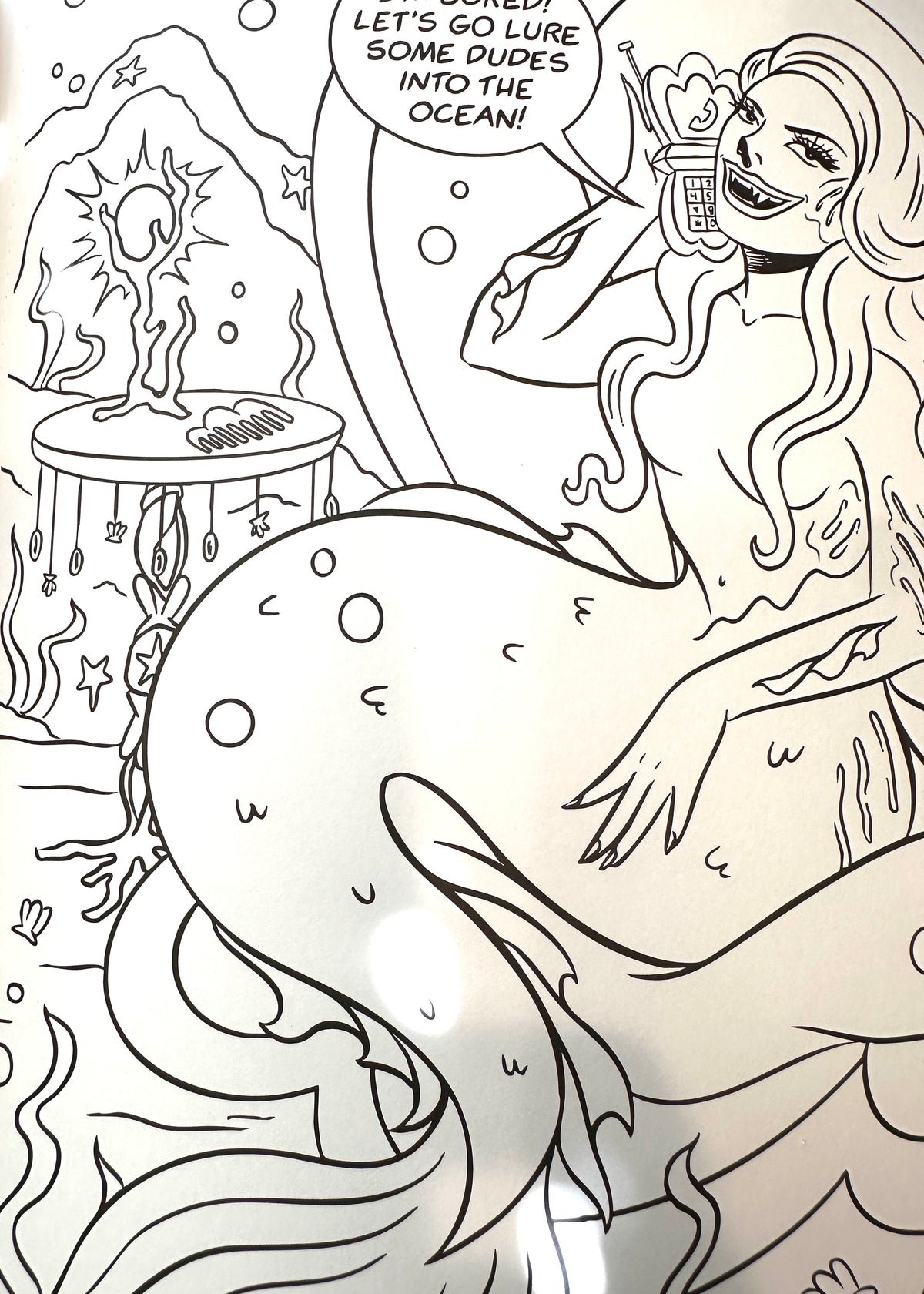 Black and white line art illustration of a mermaid sitting on a shell, holding a flip phone to her ear, with a speech bubble that reads 'LET'S GO LURE SOME DUDES INTO THE OCEAN!'.