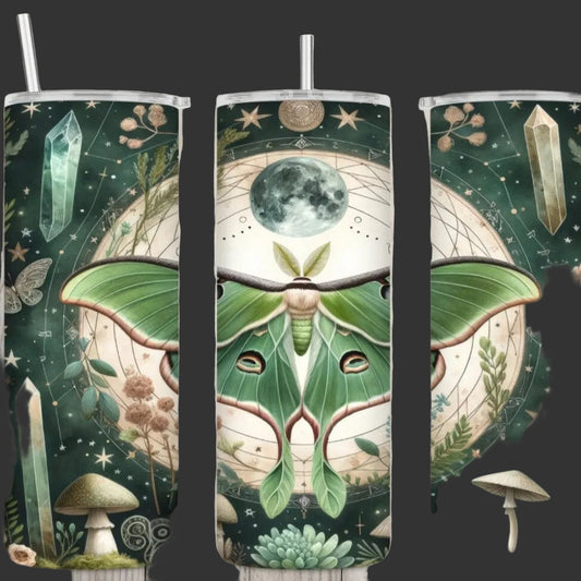 One tumbler showing all three sides with metal straws, featuring a matching celestial and botanical wrap design. The design showcases a large green luna moth, a full moon, crystals, stars, mushrooms, and succulents on a dark green background, set against a light wood plank backdrop.