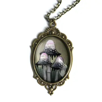 An antique bronze oval pendant necklace featuring a gothic illustration of three dripping mushrooms, suspended from a matching chain against a plain white background.