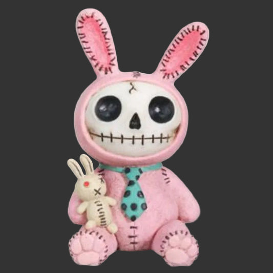 A pink stitched spooky furrybones bunny figurine with a skull face, holding a small beige bunny doll, on a plain black background.