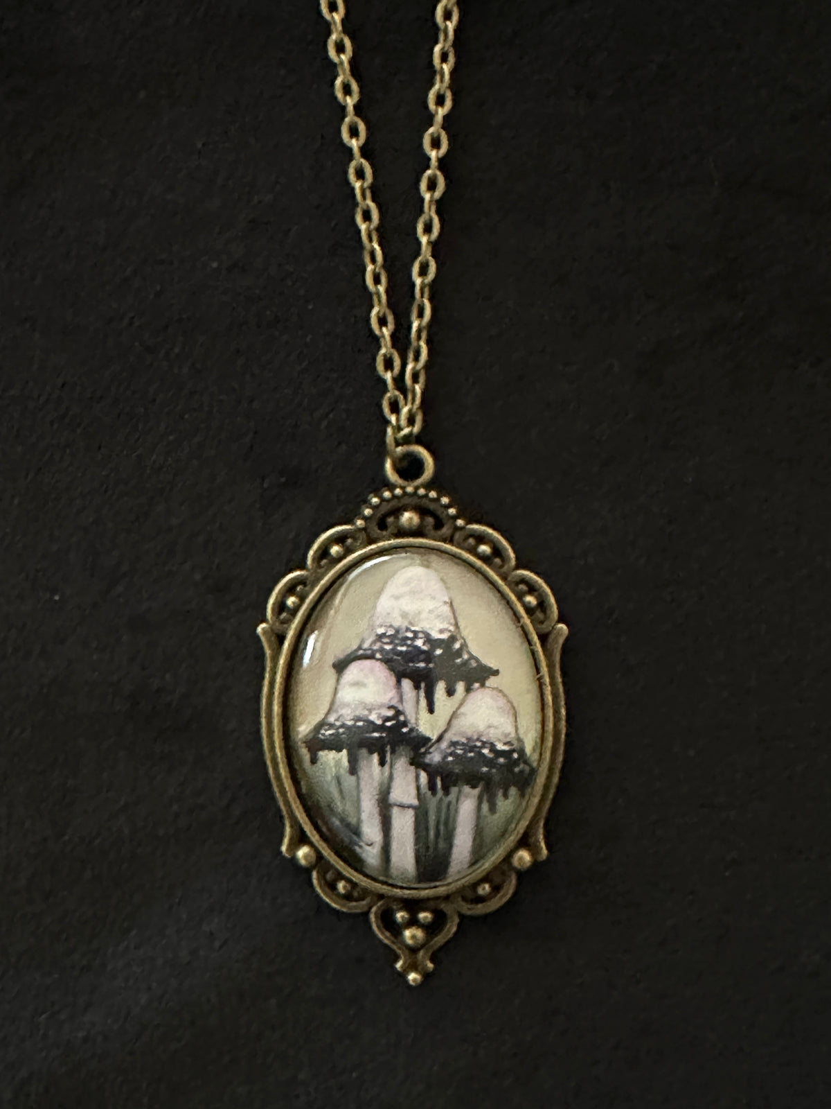 Inky Cap Mushroom cameo pendant necklace with antique brass oval frame and hand-painted mushroom art on a black background