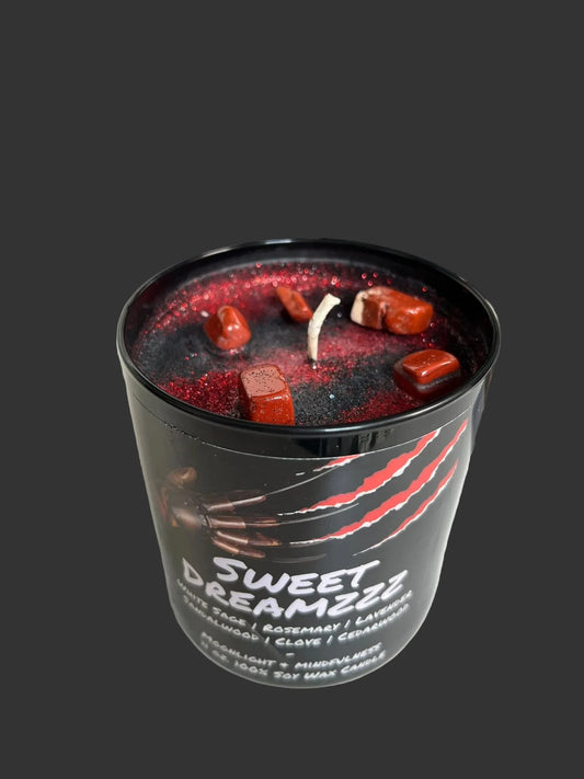 Horror movie candle with red wax and visible wick in a black container labeled 'Sweet Dreamzzz' on a white surface.