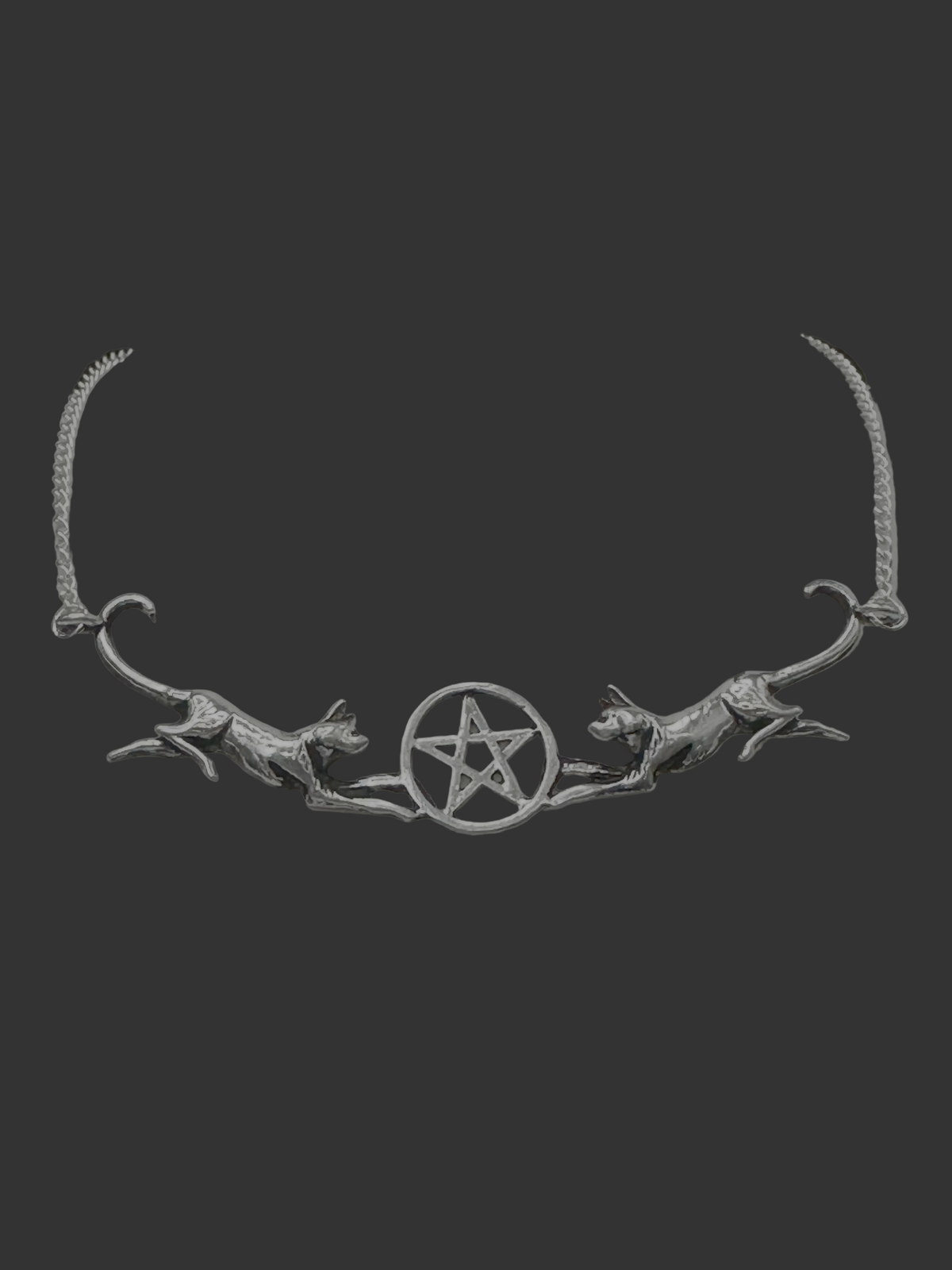 A silver-toned necklace displayed on a white jewelry bust against a dark background. The necklace features two leaping cats flanking a central pentagram symbol on a chain.