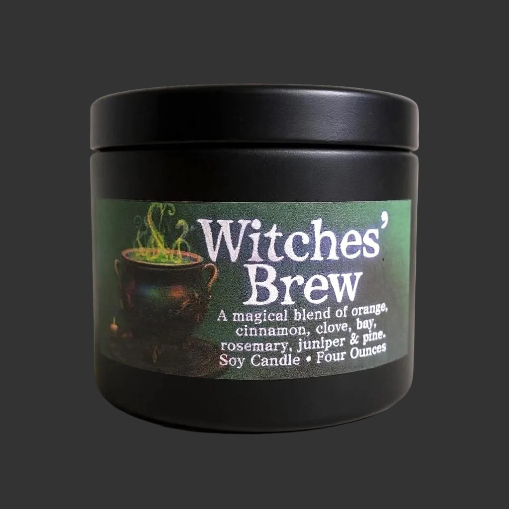 A black tin jar candle with a matching lid, featuring a green label that reads 'Witches' Brew' with a cauldron illustration and scent notes of orange, cinnamon, clove, bay, rosemary, juniper, and pine.
